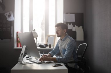 Genç erkek Tasarımcısı grafik tableti kullanarak com ile çalışırken