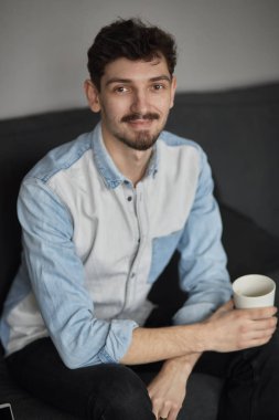 Bir fincan kahve düşünürken bir kanepede ile dinlenme serbest meslek