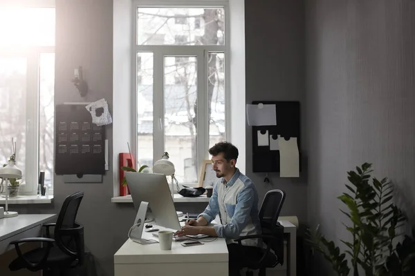 Jonge intelligente bebaarde man werken in moderne loft studio-zetel — Stockfoto