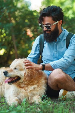 Adam sakal ve onun küçük sarı köpek oynama ve güneş zevk