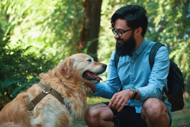 Golden retriver açık havada olan yakışıklı genç adam
