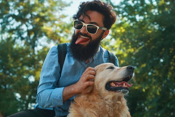 Άνθρωπος και σκύλος διασκεδάζοντας, παίζοντας, να κάνει αστεία πρόσωπα ενώ ημικλινήρη θέση — Φωτογραφία Αρχείου