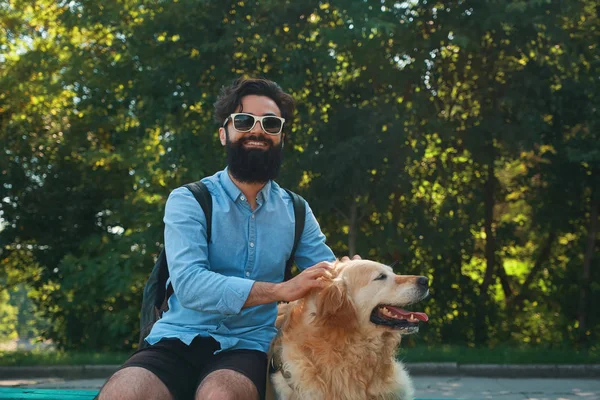 İlginç adam köpeğiyle en park sandalyede oturuyor — Stok fotoğraf