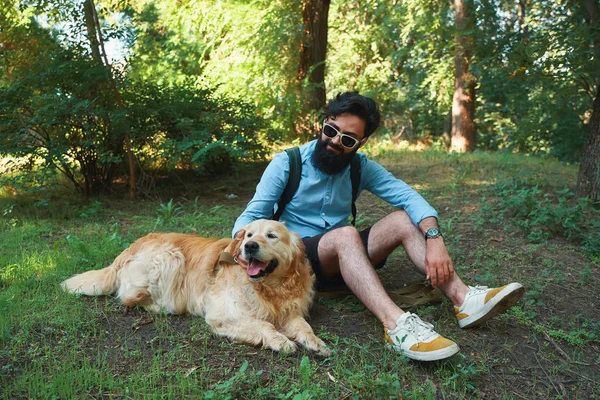 Adam sakal ve onun küçük sarı köpek oynama ve güneş zevk — Stok fotoğraf