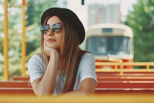 Jeune femme avec chapeau et lunettes de soleil lors d'une visite de la ville — Photo