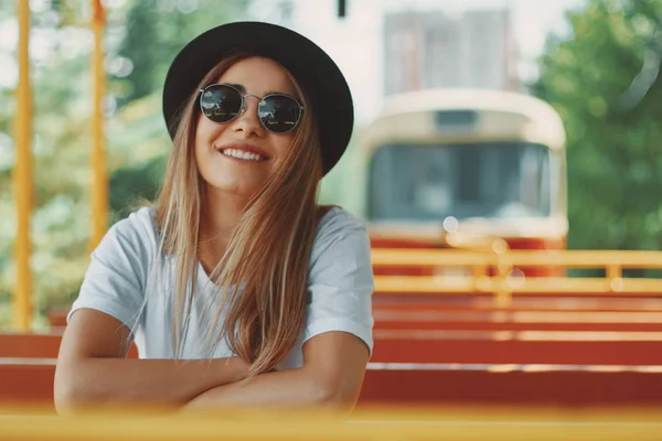 Молода жінка з капелюхом і сонцезахисними окулярами на екскурсії містом — стокове фото