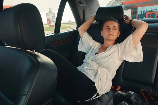 Femme est assise sur le siège arrière de la voiture — Photo