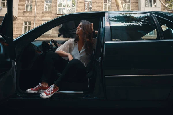 Woman getting out of a car. — Stock Photo, Image