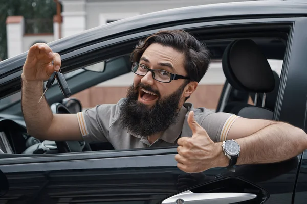 Charyzmatyczny człowiek posiadający samochód klawiszami wyświetlone thumbs up — Zdjęcie stockowe