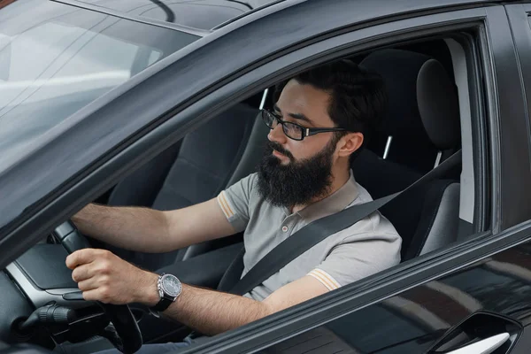 Jovem sorrindo enquanto dirige um carro — Fotografia de Stock