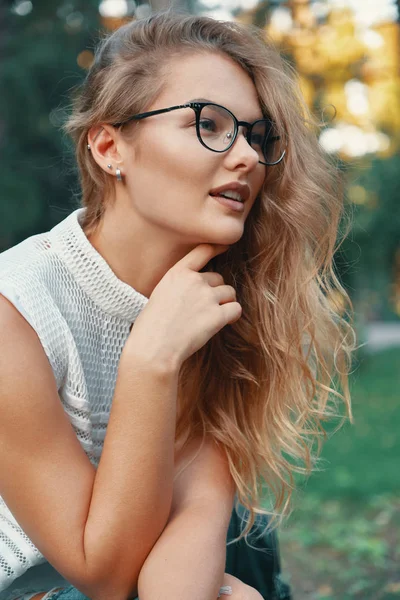 Mulher atraente usando óculos, tocando o queixo com a mão — Fotografia de Stock
