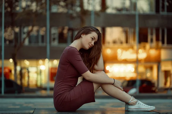 美丽的年轻女子与童话般的脸的侧面景观特色享受城市景观与灯光的背景 美丽的城市女孩肖像穿着礼服和白色运动鞋 — 图库照片