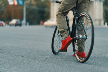 Portre rahat adam bacak Klasik Bisiklet kırmızı şehir gri yol elbise spor ayakkabı, rahat pantolon sürme. Kopya alanı
