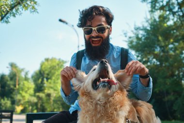 Adam ve eğleniyor, oynarken, parkta dinlenme sırasında komik surat köpek. Hayat güzel, en iyi arkadaş kavramdır.