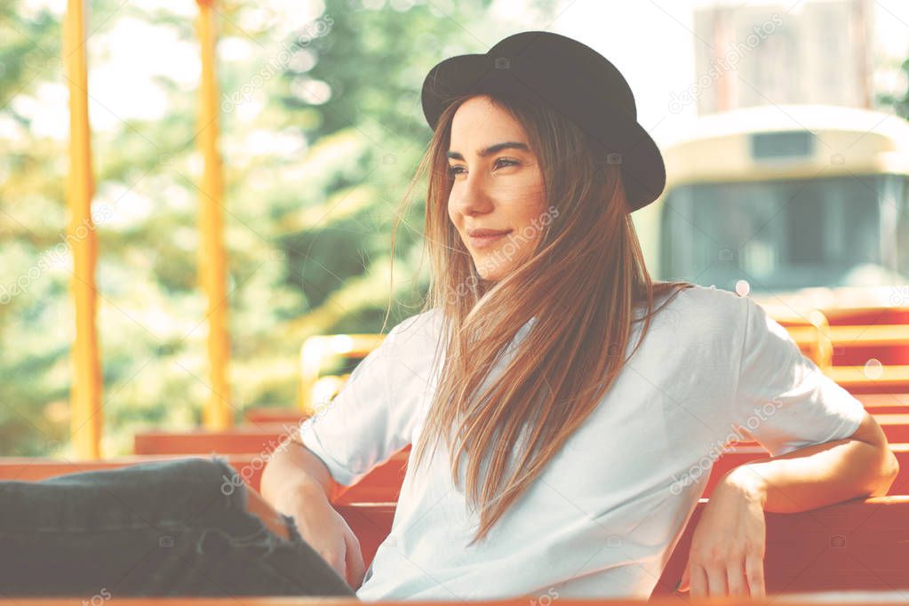 Close-up cool hipster student woman portrait. Caucasian female with hat travelling on a city tour transportation watching the views, smiling happy.