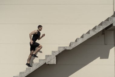 Üst, zorlukların üstesinden. Merdiven çıkma güçlü atletik erkek