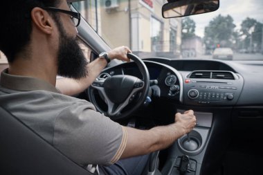 İnsanlar ve şehir yüzler kavramı. Yolun izlerken şehrin içinden onun arabayı olumlu sakallı adam. Her gün basit anlar yaşayan