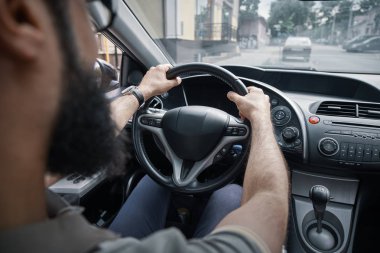 Sürüş ve yol, araba direksiyon simidi holding eller üzerinde vurgu izlerken yan arkadan görünüm adam.