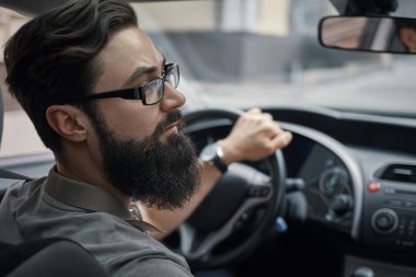 Dikkatli bir şekilde arabayı kullanan ciddi adam. Dikkatli sür. Yol sürücü dikkat