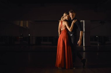 Genç güzel çift, tutkuyla dans dansçılar üzerinde ışık oyun yansıyan