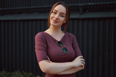 Karanlık duvara poz çekici genç kadın portresi