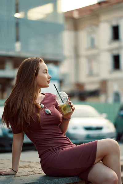 Веселая женщина на улице пьет утренний освежающий напиток — стоковое фото