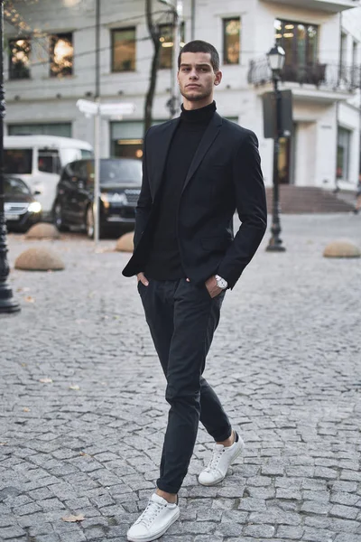 Young man walking, smart casual on an autumn day on a street of European City. Lifestyle Photography