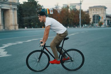 Klasik bir bisiklet şehir yolda Bisiklete binme yan görünümü modern delikanlı. Uzay kopyalayın. Etkin ve ekolojik yaşam kavramı