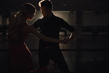 Genç güzel çift, tutkuyla dans dansçılar üzerinde ışık oyun yansıyan