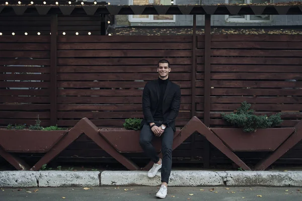 Retrato Joven Confiado Hombre Moda Vestido Con Traje Sentado Contra —  Fotos de Stock