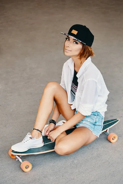 ロングボードでポーズ笑顔都会の女の子 市内のスケートで内気な少女 極端なスポーツや感情の概念 — ストック写真