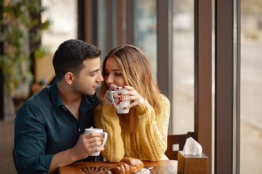 Kahve Dükkanı'tarihte genç çekici çift. Adam ve bir kafede oturan kadın kahve içme