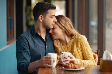 Kahve Dükkanı'tarihte genç çekici çift. Adam ve bir kafede oturan kadın kahve içme