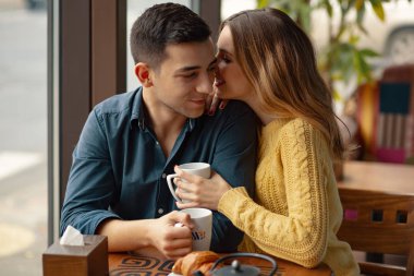 Kahve Dükkanı'tarihte genç çekici çift. Adam ve bir kafede oturan kadın kahve içme