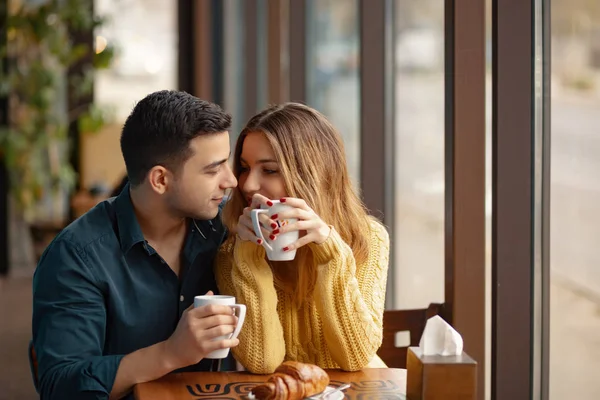 Kahve Dükkanı'tarihte genç çekici çift. Adam ve bir kafede oturan kadın kahve içme
