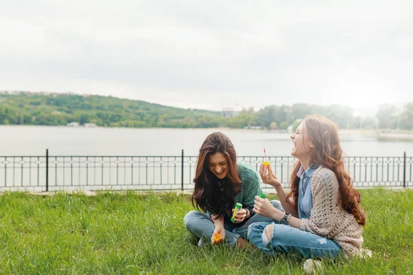 Two Sisters Having Fun While Making Bubbles Sitting Grass Lake — Stock Photo, Image