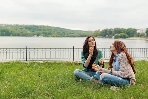 Two Sisters Having Fun While Making Bubbles Sitting Grass Lake — Stock Photo, Image