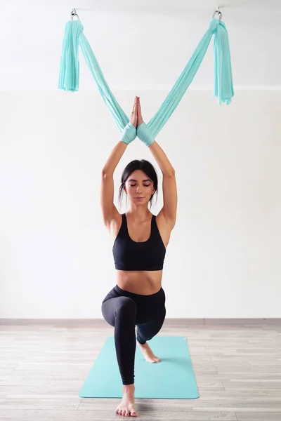 Donna adulta pratica la posizione anti-gravità yoga in studio — Foto Stock