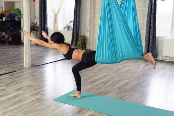 Donna adulta pratica la posizione anti-gravità yoga in studio — Foto Stock