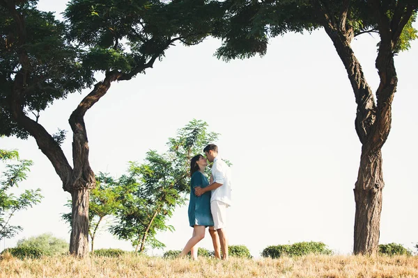 若いカップルは 彼らの赤ちゃんを待っている間世界中の旅行します 優しさと木々 澄んだ空と黄色の草と素晴らしい風景に休んでいる間の子育ての役割を見越しての瞬間 — ストック写真