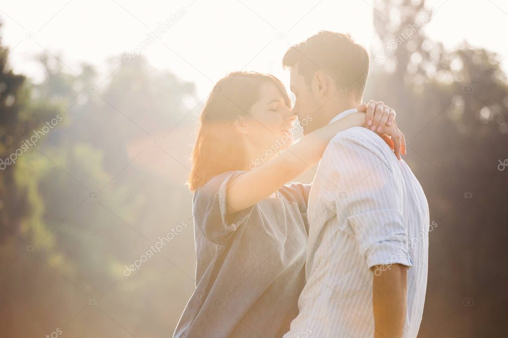 In love couple enjoying moments together looking tender to each other ready to kiss in the sunlight.