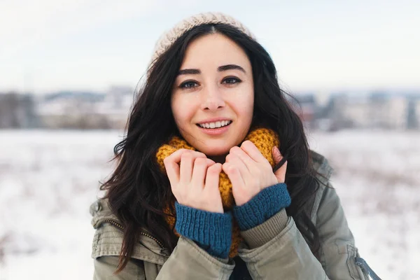 Heart melting winter portrait of pretty young woman enjoying winter, vacation, snow, holiday and her comfy, beautiful clothes and a warm woollen sweater, snood and beanie. Winter dreamy girl