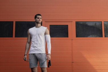  Portre atletik kaslı adam posig. İp atlama eğitimi, gücü egzersiz kavramı.