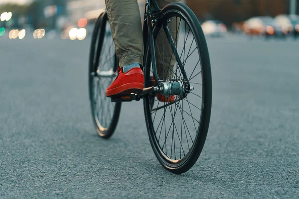 特写的休闲男子腿骑经典自行车在城市灰色的道路上穿着红色运动鞋和舒适的裤子 复制空间 — 图库照片