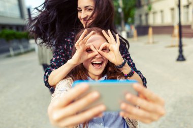 Komik selfie sokakta yapmak, birlikte, uçan saç, sevinç, mutluluk, sevgi, arkadaşlık, kız kardeş eğleniyor güzel kızlar