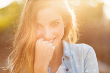 Güzel bir gülümseme ve güneş ışınları ile muhteşem kız onu mutlu yüzüne yansıyan