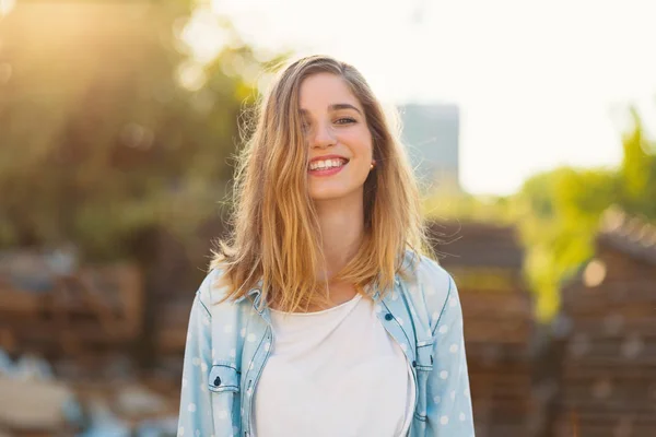 Hermosa chica con una hermosa sonrisa y rayos de sol reflejados en su cara feliz —  Fotos de Stock