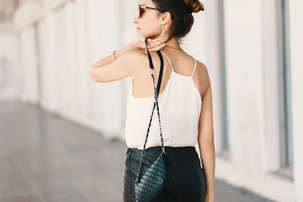 Hermosa joven sonriente con gafas de sol mirando por encima del hombro —  Fotos de Stock