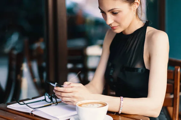 Bella donna d'affari che beve caffè e utilizza il telefono — Foto Stock