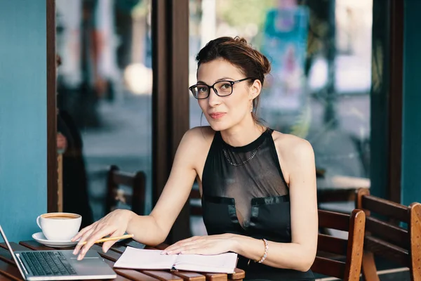 Kifinomult üzleti nő a szemüveg, ült az asztalnál kávézóban dolgozó laptop — Stock Fotó